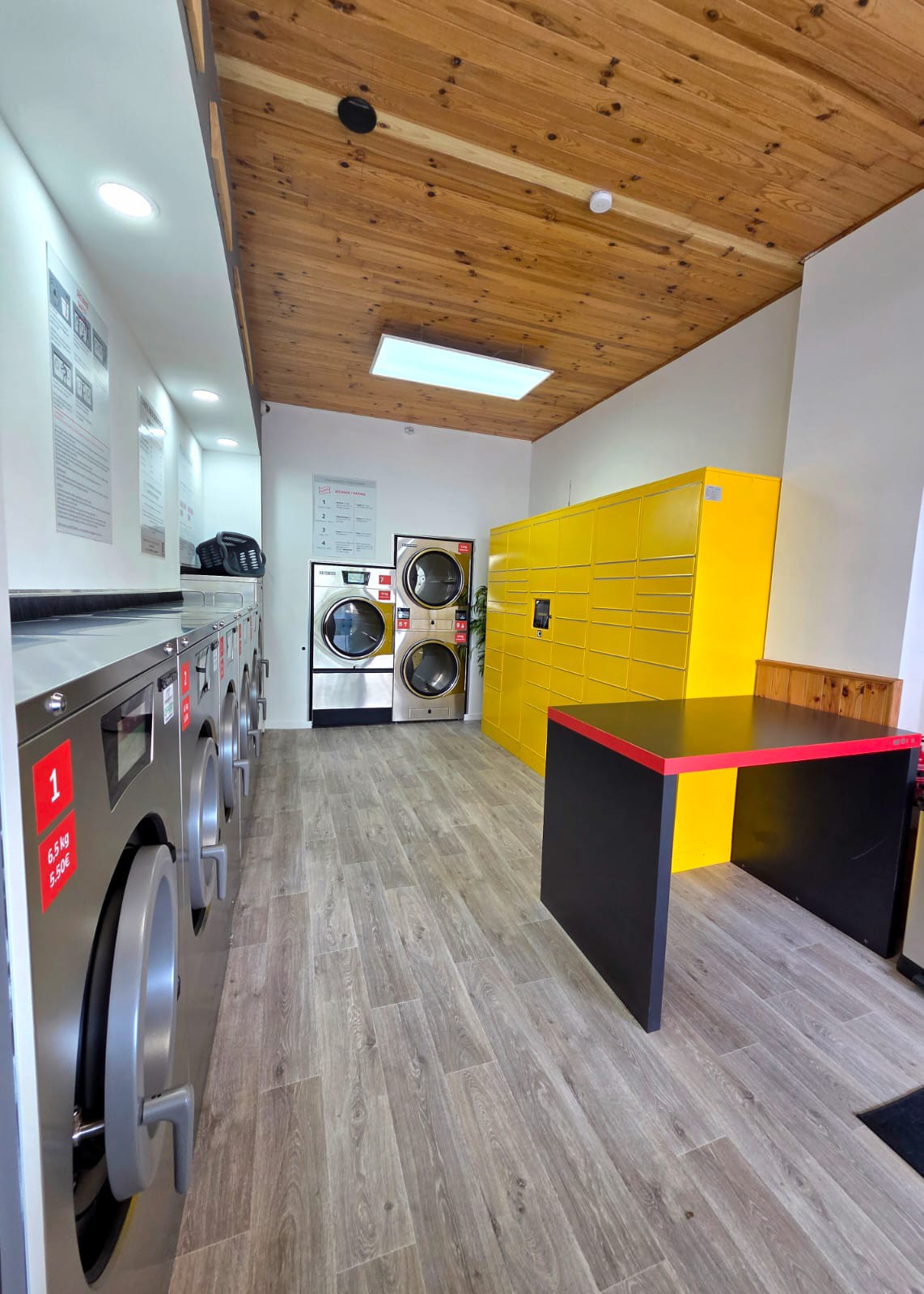 Vue complète de la laverie — machines à laver, casiers Amazon Locker et table de pliage
